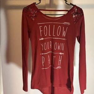Red long sleeve shirt with lace on the sleeves.